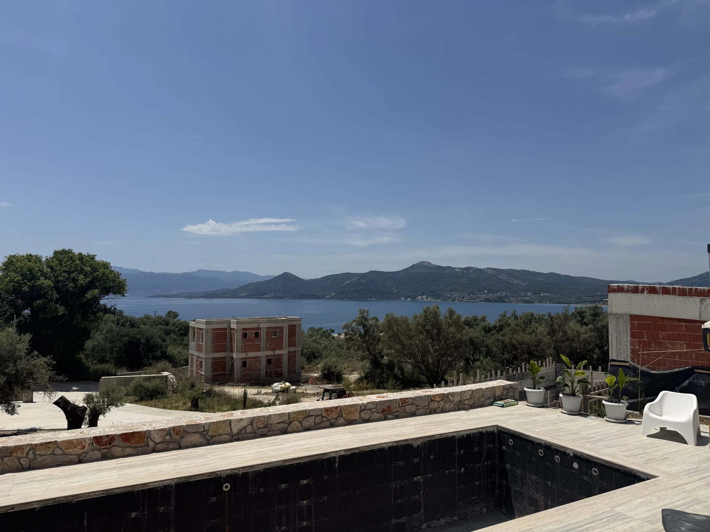Private pool on the terrace of Villa Prima framed by olive trees, with panoramic views over the bay and mountains near Paleros.