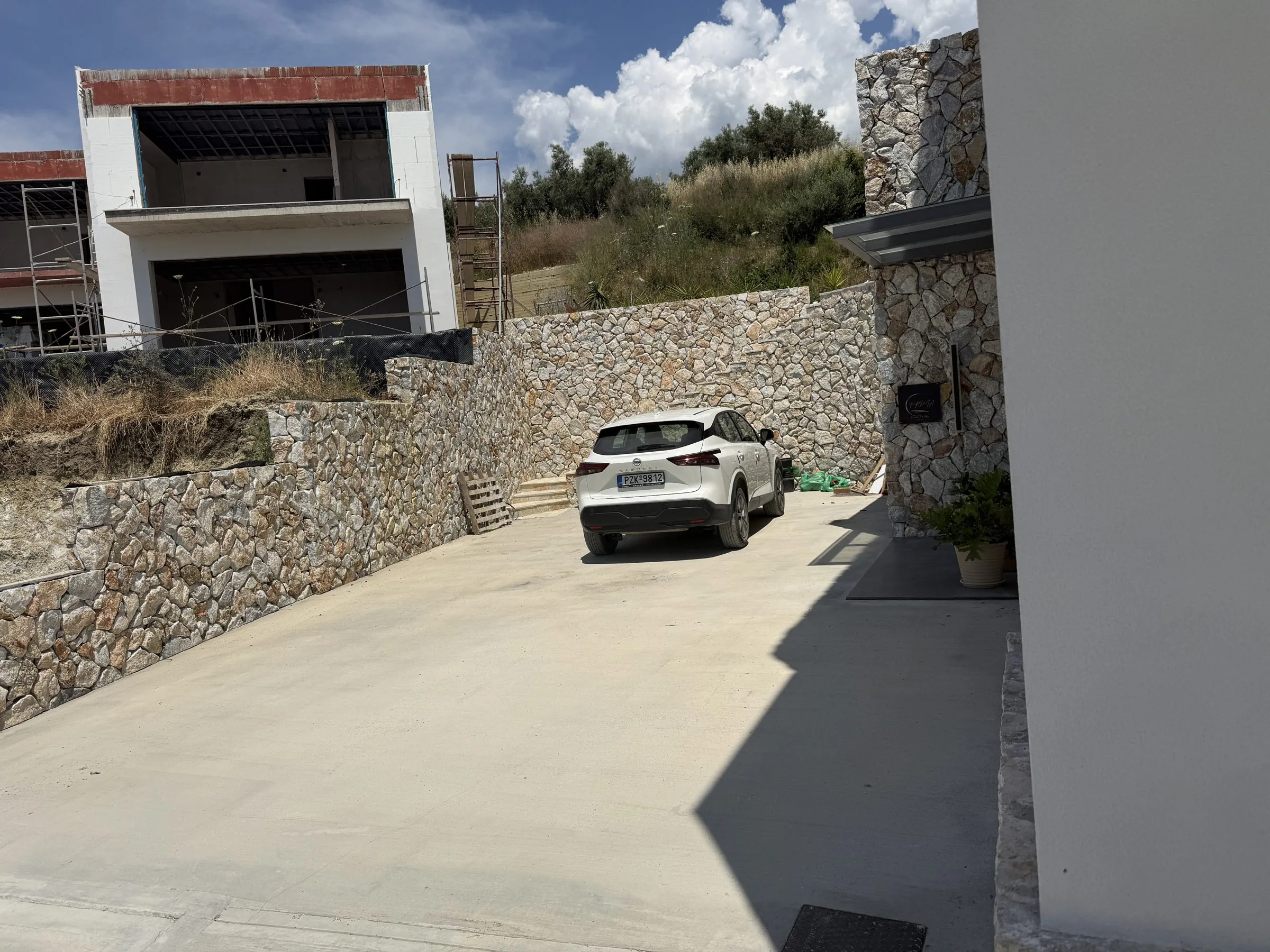 Private driveway and stone-walled entrance at Villa Prima, with on-site parking.